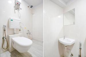 a white bathroom with a toilet and a sink at FabHotel Grey Sky in Gandhinagar