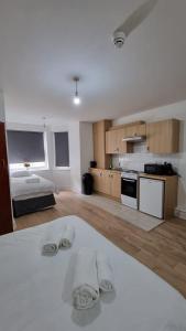 a large white room with a bed and a kitchen at Charmstay Swiss Cottage in London