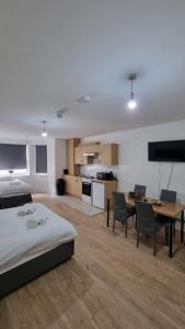 a bedroom with a bed and a table and a kitchen at Charmstay Swiss Cottage in London