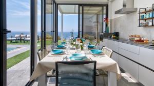 un comedor con una mesa con platos azules en VILLA SABBIE ROSSE 6, Emma Villas en Ovile la Marinella