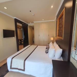 1 dormitorio con 1 cama grande con sábanas y almohadas blancas en Admiral Premier Bangkok, en Bangkok