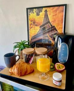 a table with a breakfast of bread and orange juice at Beau studio haut standing de 30m2 in Montreuil +3 photos