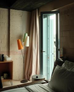 um quarto com uma cama e uma grande janela em Rooms Hotel Batumi em Batumi