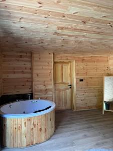 uma casa de banho com banheira num quarto de madeira em Karadeniz Suit em Rize