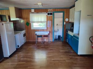 een keuken met blauwe kasten en een tafel en een raam bij Haugheim Two-Bedroom Cottage in Birkeland