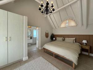 ein Schlafzimmer mit einem großen Bett und einem Kronleuchter in der Unterkunft High tide at no 16 in St Francis Bay + 16 Fotos