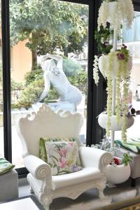a white chair in front of a window with a statue at Hotel Okinawa in Rimini
