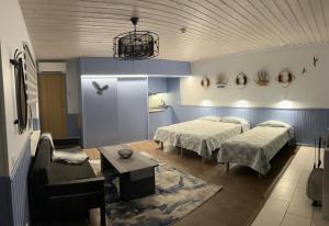 a bedroom with two beds and a table and a couch at Apartments Weintrauben in Pärnu