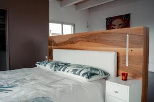 a bedroom with a large bed with a wooden headboard at LE SITE in Specchia +6 photos