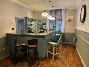 a bar in a room with chairs and a counter at Leonardo Edinburgh City in Edinburgh