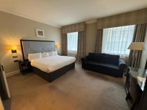 una camera d'albergo con letto e divano di Leonardo Edinburgh City a Edimburgo