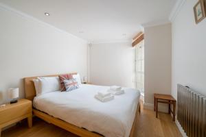 - une chambre avec un lit doté de draps blancs et une fenêtre dans l'établissement Great flat near St Paul’s Cathedral, à Londres