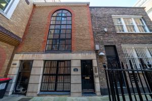 - un bâtiment en briques avec de grandes fenêtres donnant sur une rue dans l'établissement Great flat near St Paul’s Cathedral, à Londres