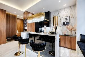 a kitchen with a bar with black chairs at Premium Glamour by LookAp in Łódź