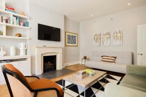 een woonkamer met een bank en een open haard bij The West Kensington Hideout - Cozy 2BDR Flat with Garden in Londen