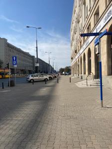 ulica z samochodami zaparkowanymi po stronie budynku w obiekcie Apartment 82A w Warszawie
