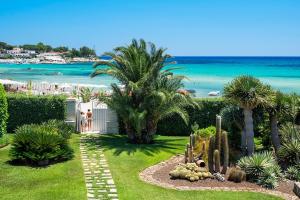 un giardino con vista sulla spiaggia e sull'oceano di La Plage a Fontane Bianche
