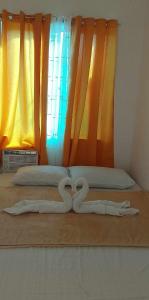 ein paar Handtücher in Form von Herzen auf einem Bett in der Unterkunft TMD COMFORTABLE TRANSIENT HOUSE IN STO.TOMAS BATANGAS in San Felix