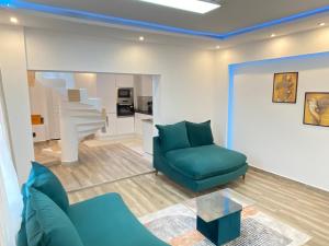 博韋的住宿－Maison spacieuse et élégante，客厅设有蓝色的沙发和楼梯。