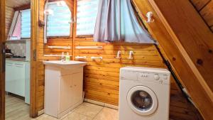 a bathroom with a washing machine and a sink at VIVA SOLE domek Nr 7 Ośrodek Wypoczynkowy Skorzęcin in Skorzęcin +1 photo