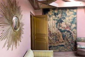 ein großer Wandteppich hängt an einer Wand neben einer Tür in der Unterkunft Maison d'hôtes Stella Cadente in Provins