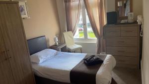 1 dormitorio con 1 cama, vestidor y ventana en Royal Grosvenor Hotel, en Weston-super-Mare