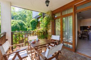 een patio met een houten tafel en stoelen op een balkon bij Apartments DreamBG in Sozopol