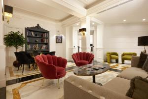 un soggiorno con sedie rosse e un pianoforte di Hotel Barberini a Roma