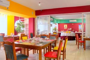 Hotel LIVVO Don Paco في منديلو: غرفة طعام مع طاولات وكراسي وجدران ملونة