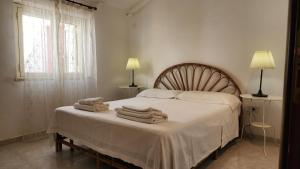 1 dormitorio con 1 cama con toallas en Villa Mediterraneo, en Fontane Bianche