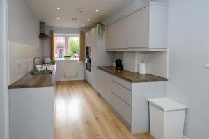 una cucina con mobili bianchi e pavimento in legno di Dings House With FREE Parking In Super Central South West City Location By StayStaycations a Bristol