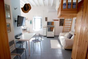 a kitchen and living room with a couch and a table at Lily's Studio in Astypalaia Town