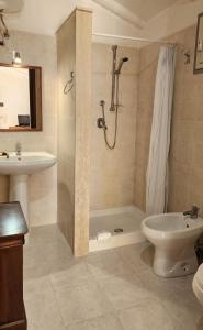 y baño con ducha, aseo y lavamanos. en Villa Mediterraneo, en Fontane Bianche