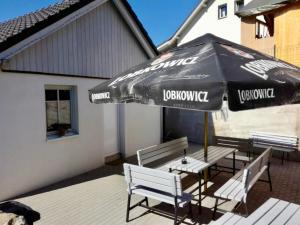 a patio with two benches and an umbrella at Chata u Myšáka in Maxov