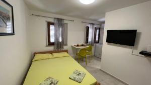 a bedroom with a bed and a table and a tv at Royal Garden Apartments & Gastronomy in Budva