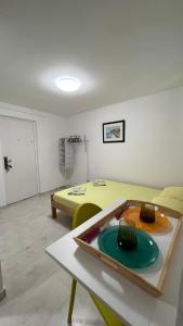 a room with a yellow bed and a table at Royal Garden Apartments & Gastronomy in Budva