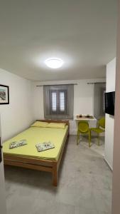 a bedroom with a bed and a table and chairs at Royal Garden Apartments & Gastronomy in Budva