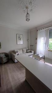 Sala de estar blanca con sofá y mesa en Appartement Colmar Centre Le 4, en Colmar