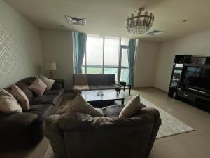 a living room with two couches and a tv at Luxury 1BR Uninterrupted Sea View, Fully Equipped in Ras al Khaimah