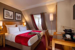 een hotelkamer met een bed en een bureau met een bureau bij Royal Saint Michel in Parijs