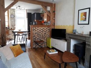 - un salon avec un canapé et une cheminée dans l'établissement Maison avec patio centre ville quartier calme, à Arbois