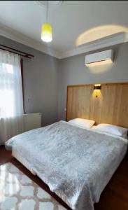 una camera con un grande letto con testiera in legno di Four seanson müstakil sıcak havuzlu villa a Sapanca