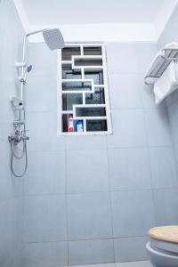 uma casa de banho com um chuveiro, um WC e uma janela. em Olive homes em Kampala