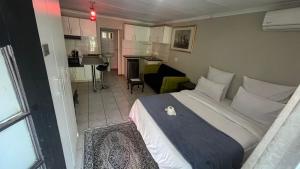 a bedroom with a large bed and a living room at RAMATA GUEST HOUSE in Pretoria