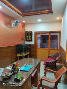 ein Wohnzimmer mit einem Tisch und 2 Stühlen in der Unterkunft OYO 81239 Shri Vinayaka Inn Rooms in Tiruchchirāppalli