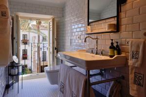 uma casa de banho com um lavatório e um WC em La Fonda Heritage Hotel Luxury, Relais & Châteaux em Marbella