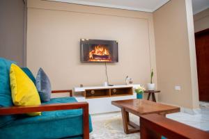 uma sala de estar com um sofá e uma lareira em Olive homes em Kampala