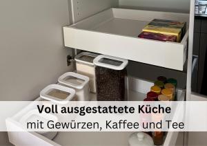 克羅伊茨林根的住宿－Ferienhausträume Oase Bodensee，一个小浴室,配有白色冰箱,字眼低估了刀叉。