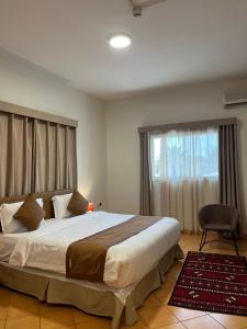 Un dormitorio con una cama grande y una ventana en اجنحة مجمع القوافل الفندقيه en Tabuk