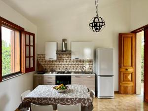 a kitchen with a table with a bowl of fruit on it at Garden Paradise near the sandy beach, parking & wifi in Marina dʼAvola